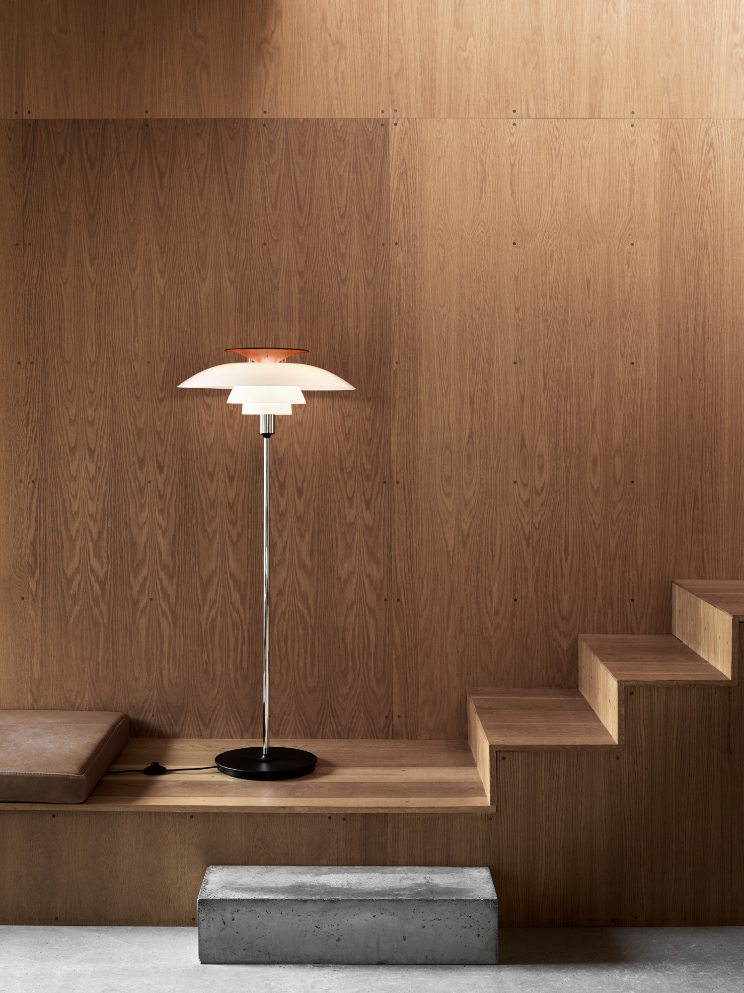 PH 80 floor lamp in white and chrome against a wooden backdrop, casting soft light, © 2025 Louis Poulsen.